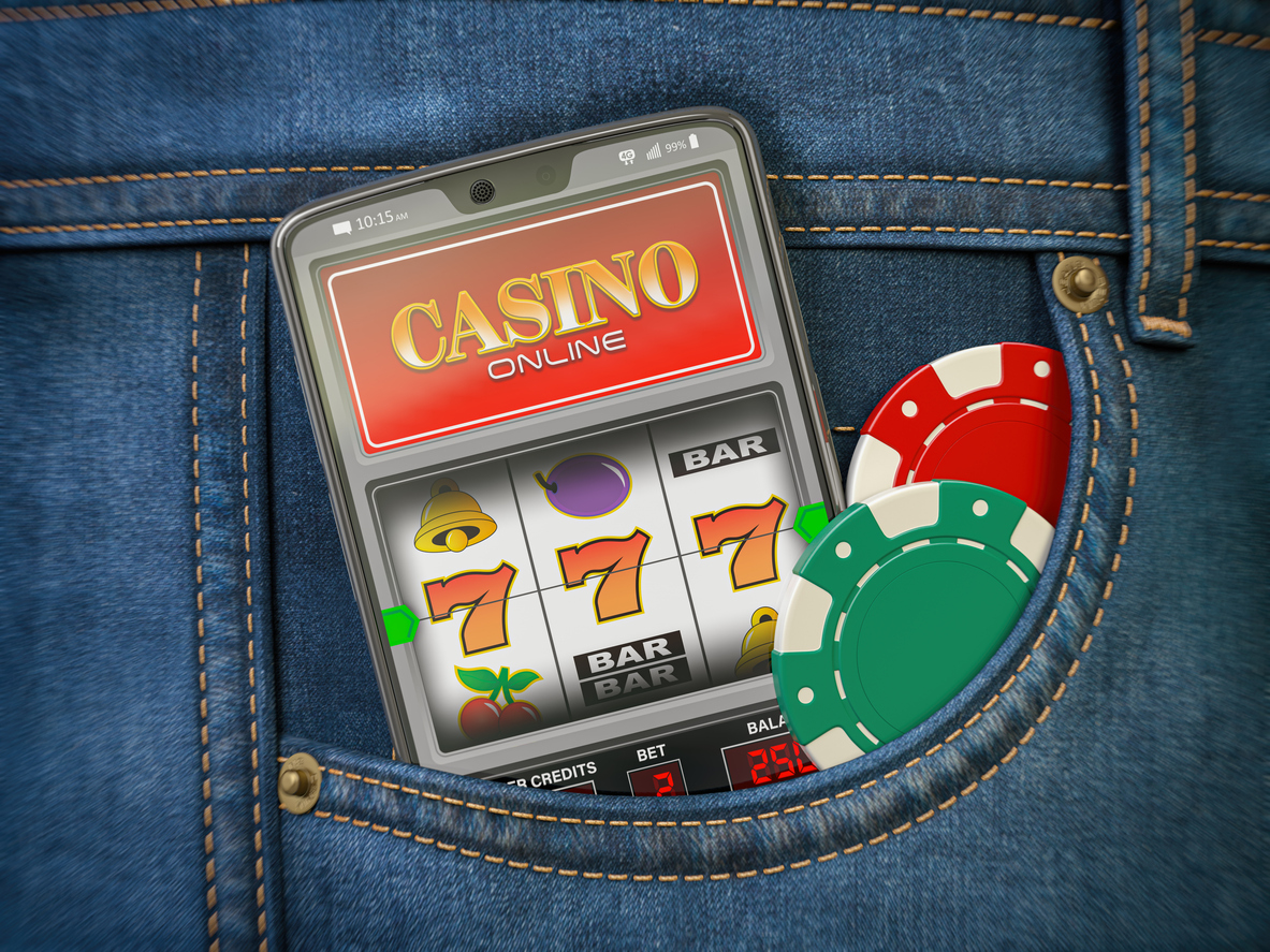 Online casino. Mobile phone or smartphone with slota machine jackpot on the screen in pocket of jeans.